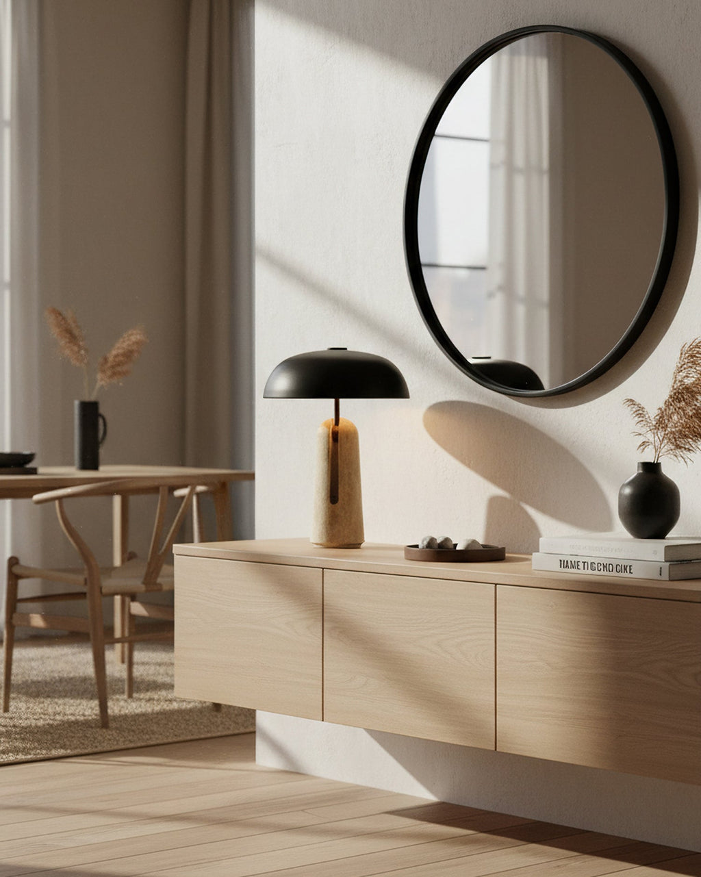 Seen from a corner, this Clérachic table lamp stands on a floating oak cabinet beside a round mirror and wishbone dining chairs.