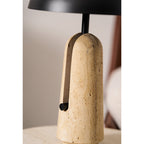 Close view of the textured travertine body and the black pull on this Clérachic table lamp, below the dome shade.