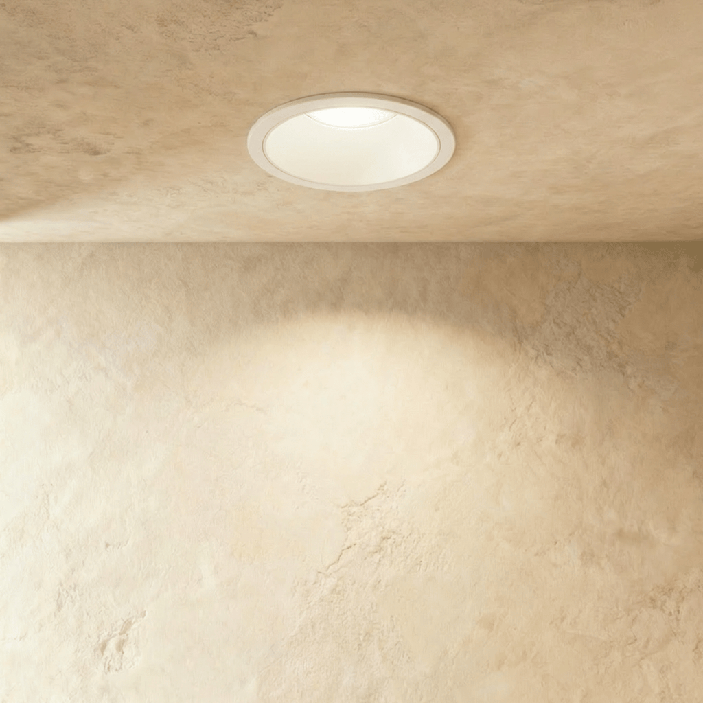 Clérachic recessed downlight in white aluminium, its round trim glowing warm white against a plastered ceiling.