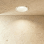 Clérachic recessed downlight in white aluminium, its round trim glowing warm white against a plastered ceiling.