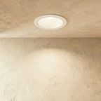 Straight-on view of the Clérachic white recessed downlight, its round trim glowing warm white overhead.