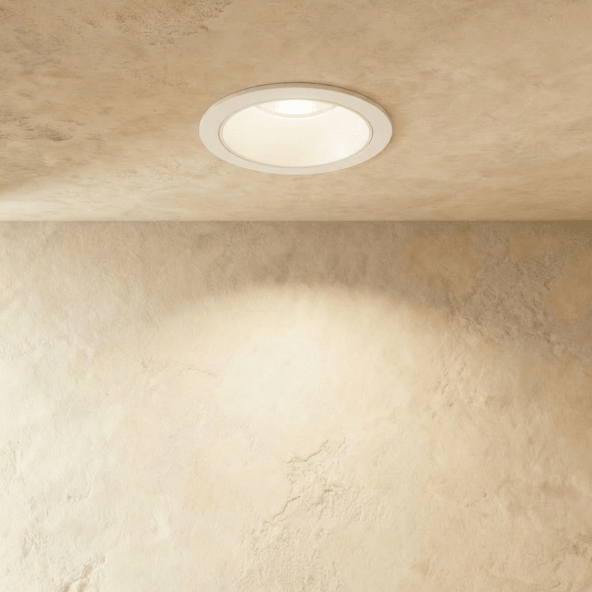 Straight-on view of the Clérachic white recessed downlight, its round trim glowing warm white overhead.