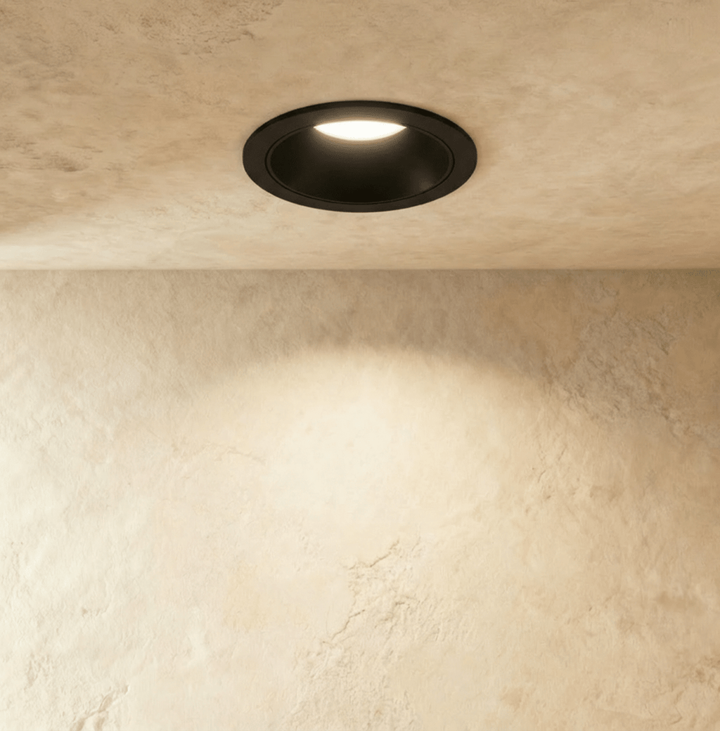 Another angle of the Clérachic black recessed downlight, its round trim glowing warm white overhead.
