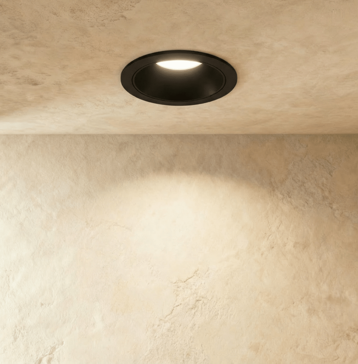 Another angle of the Clérachic black recessed downlight, its round trim glowing warm white overhead.