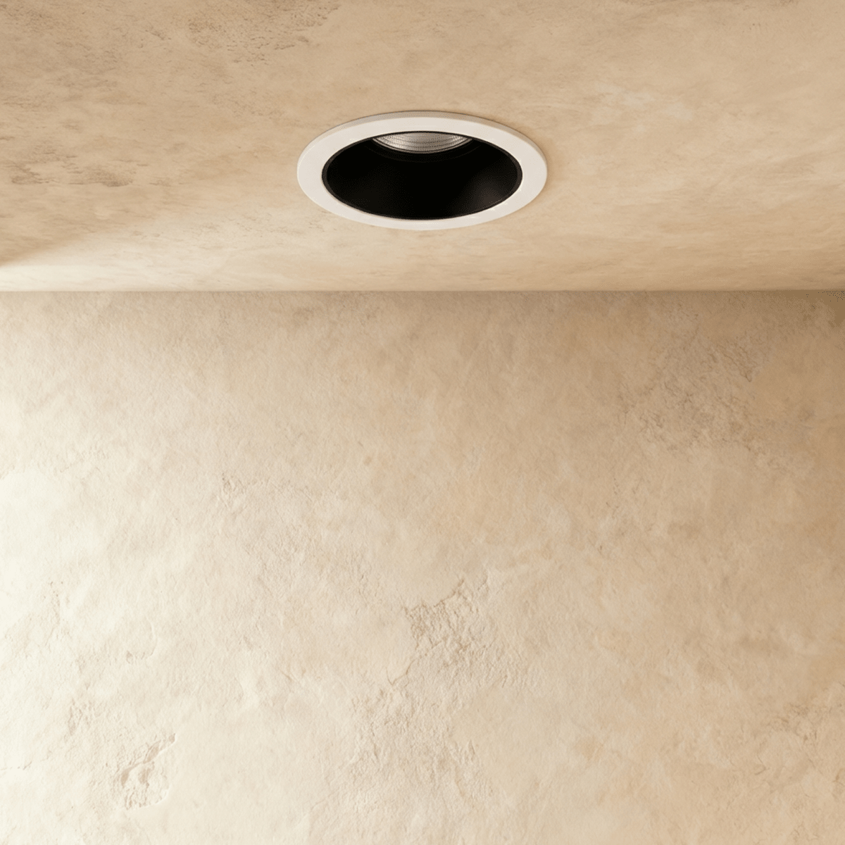 Another angle of the Clérachic black and white recessed downlight, its baffle glowing white against a plaster ceiling.