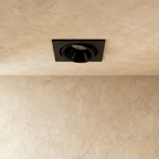 Straight-on view of the Clérachic black recessed downlight, its round tiltable head glowing warm white overhead.