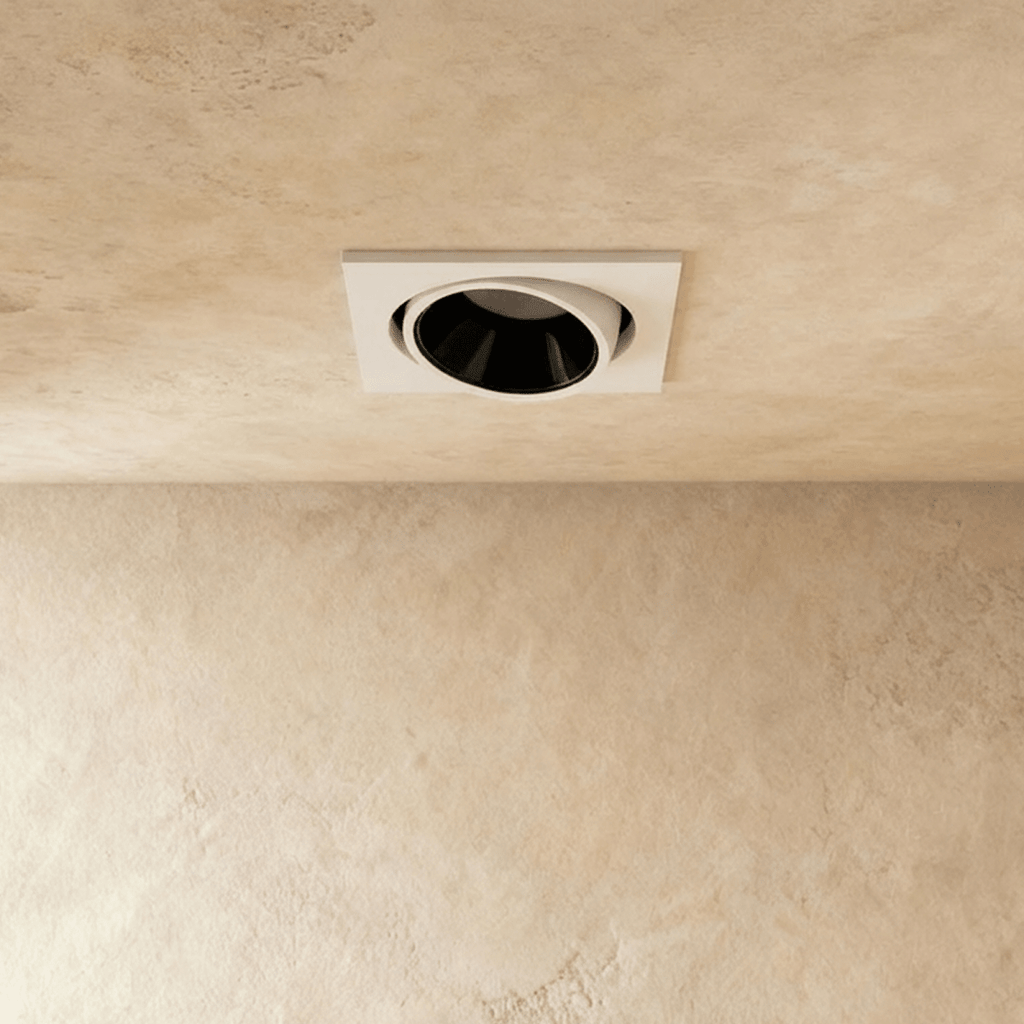 Close angle of the Clérachic white recessed downlight, its tiltable head glowing warm white overhead.