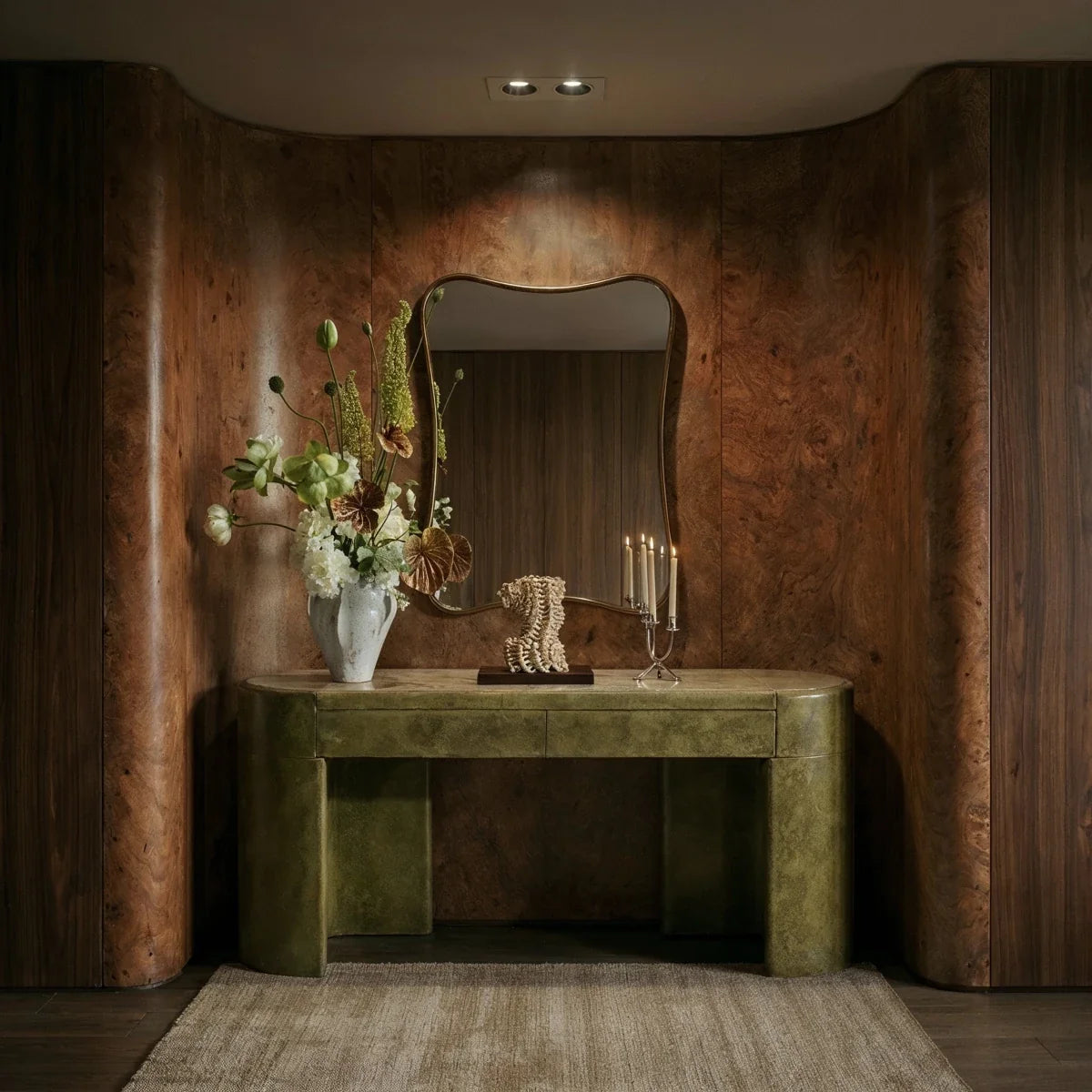 The Clérachic black two-head recessed downlight glowing warm white above a wood console with an arched mirror.
