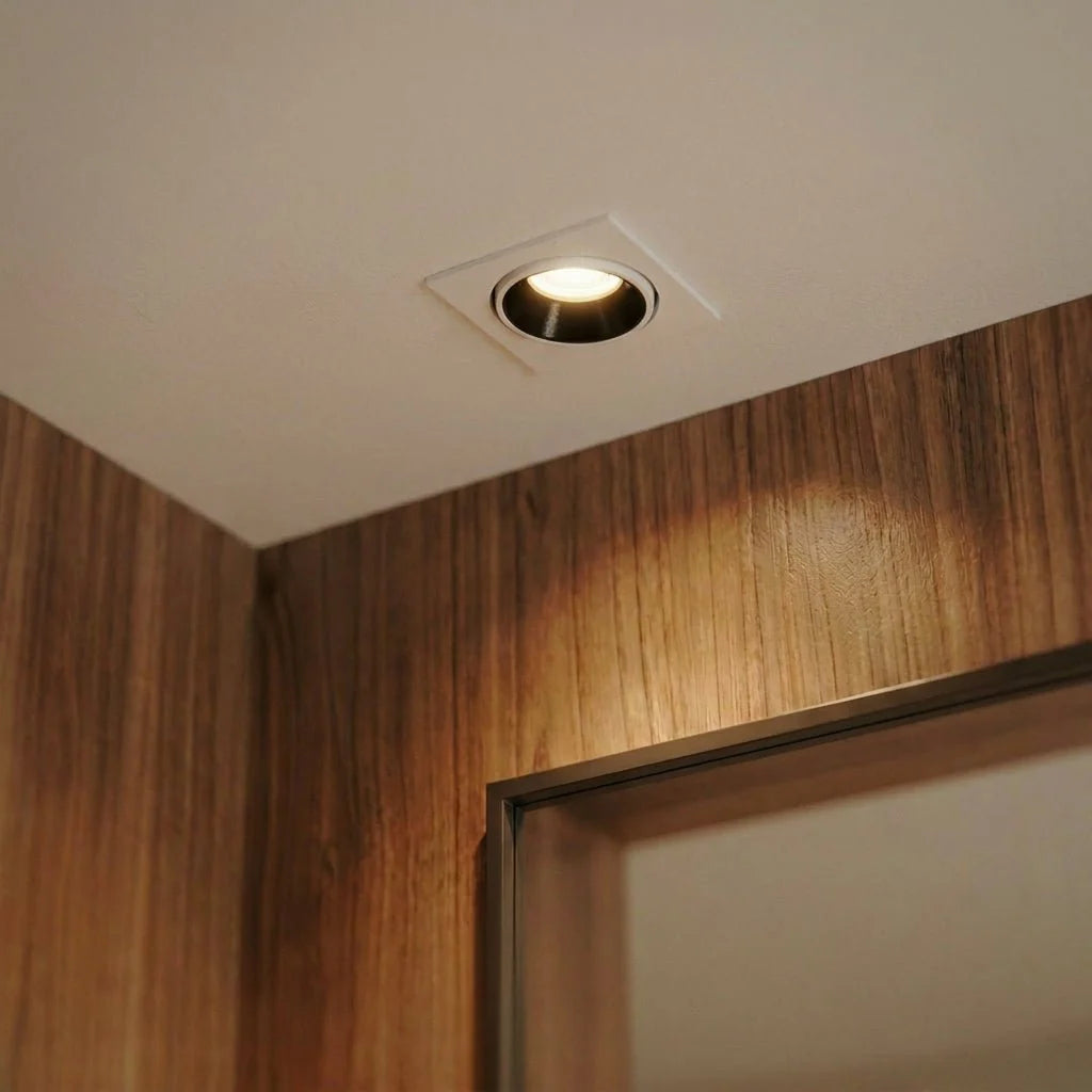 Close-up of the Clérachic white recessed downlight glowing warm white above a wood-framed doorway.