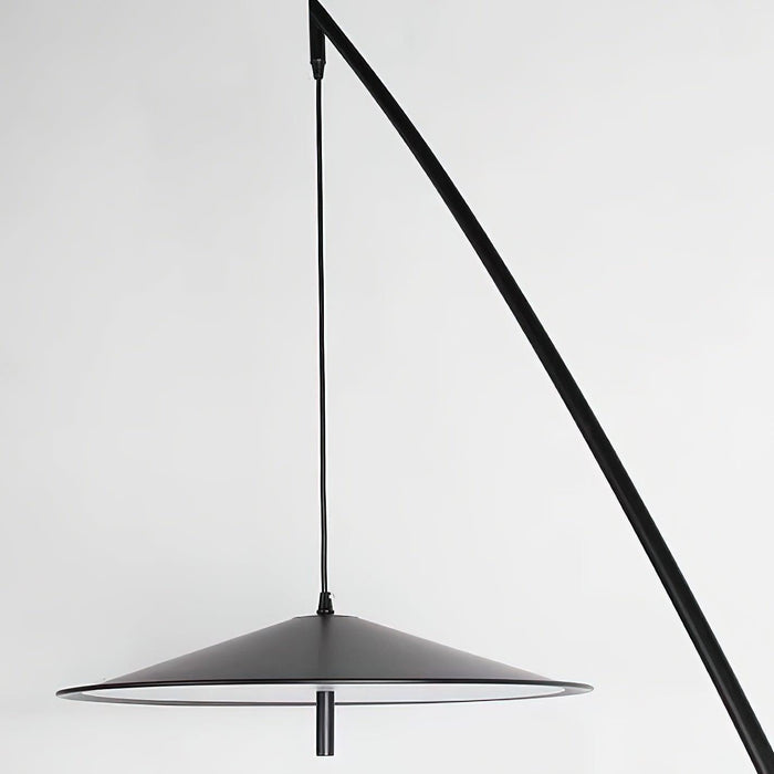 Close view of the matte black disc shade and the thin cord that hangs it from the stem, on this Clérachic floor lamp.