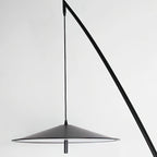 Close view of the matte black disc shade and the thin cord that hangs it from the stem, on this Clérachic floor lamp.