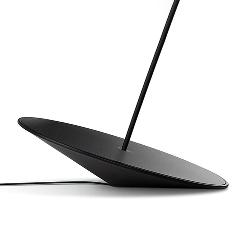 Angled base of this Clérachic floor lamp on a white surface, showing its black cord and stem rising from the centre.