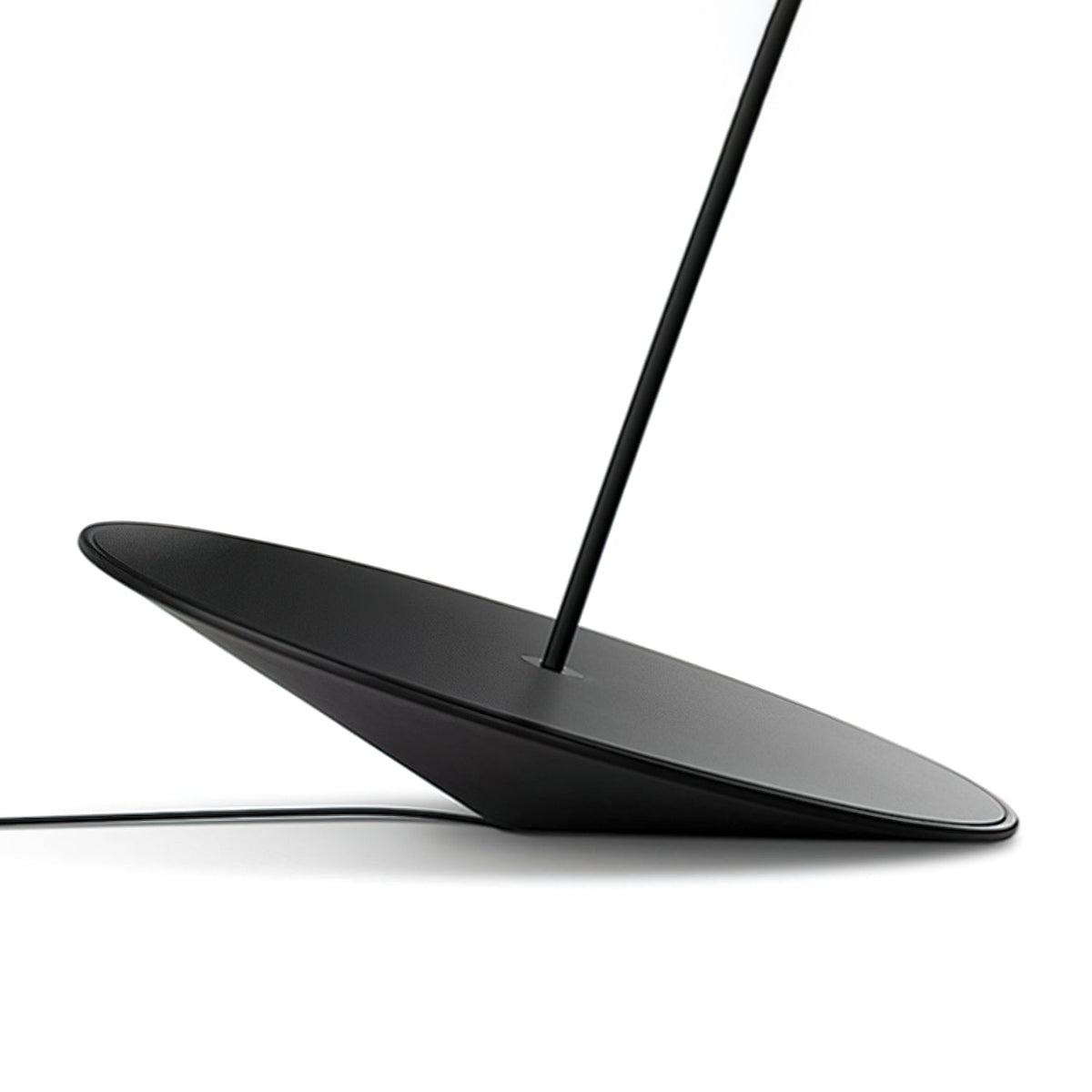 Angled base of this Clérachic floor lamp on a white surface, showing its black cord and stem rising from the centre.