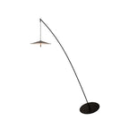 Black arc floor lamp on white, with a flat round base and a disc shade glowing a little at the edge, from Clérachic.