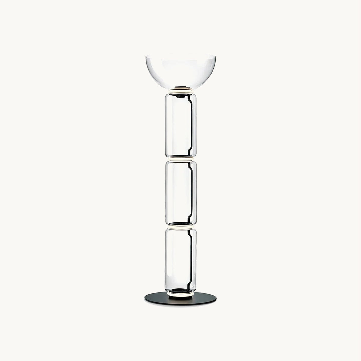 Clérachic floor lamp on a plain white backdrop, three stacked clear glass cylinders topped by a wide glass bowl on a round black base.