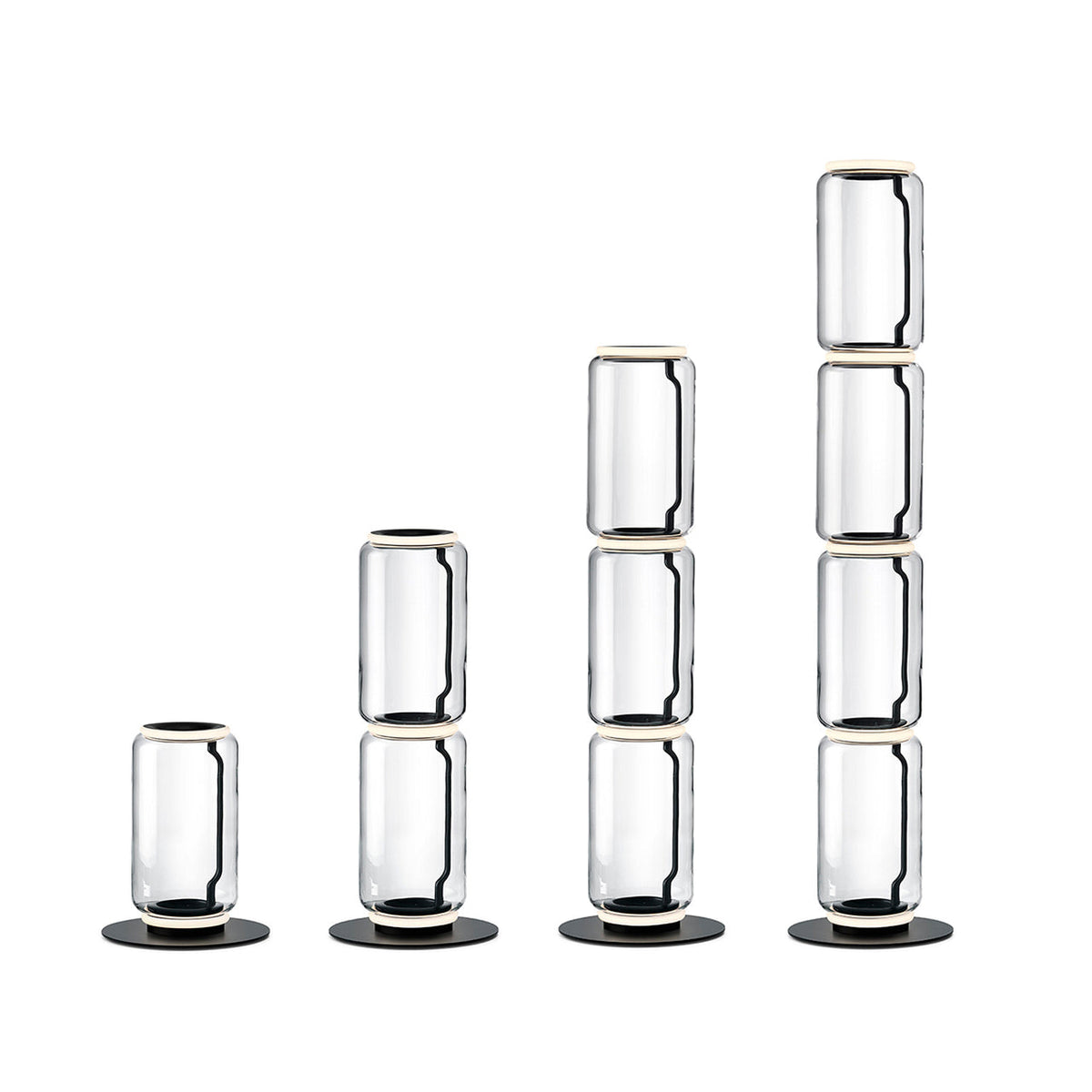 Four Clérachic floor lamps in rising heights on white, built from one to four stacked glass cylinders with round black bases.