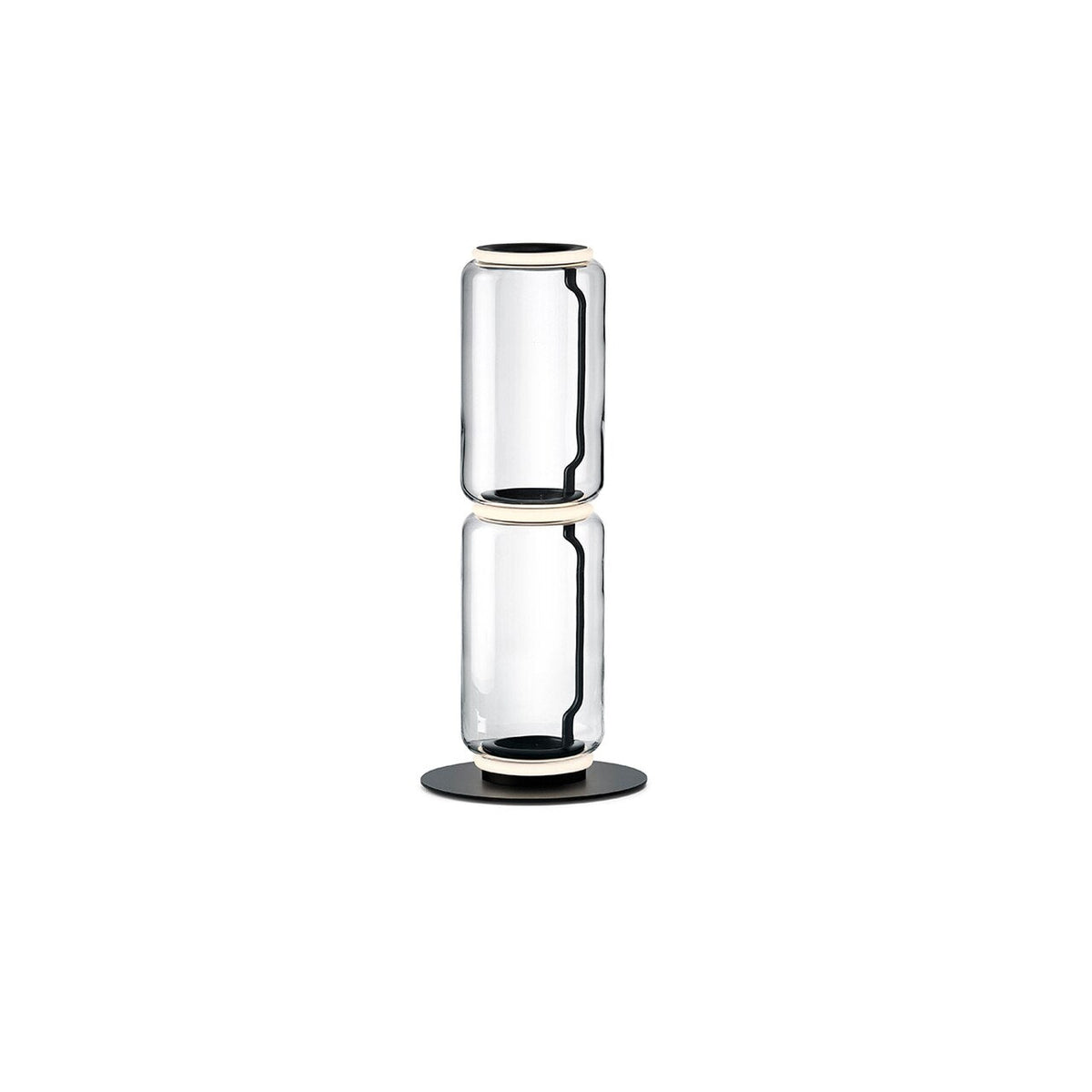 Two-cylinder Clérachic floor lamp on a white backdrop, clear glass drums joined by a glowing ring on a round black base.