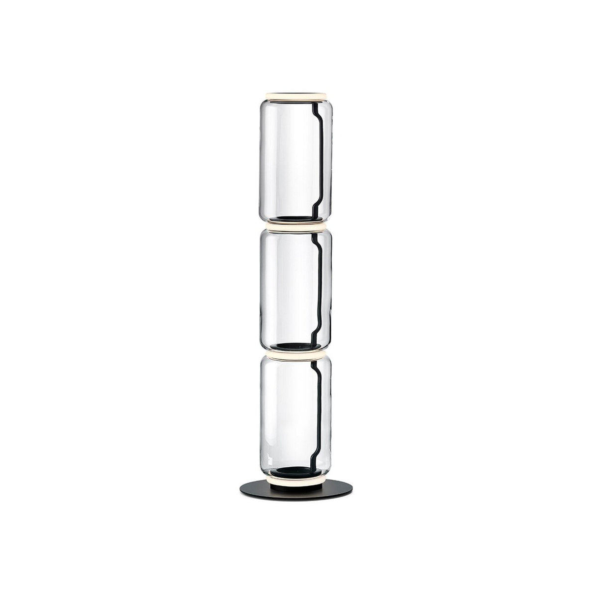 Clérachic floor lamp on white, three stacked clear glass cylinders with glowing rings at each join and a round black base.