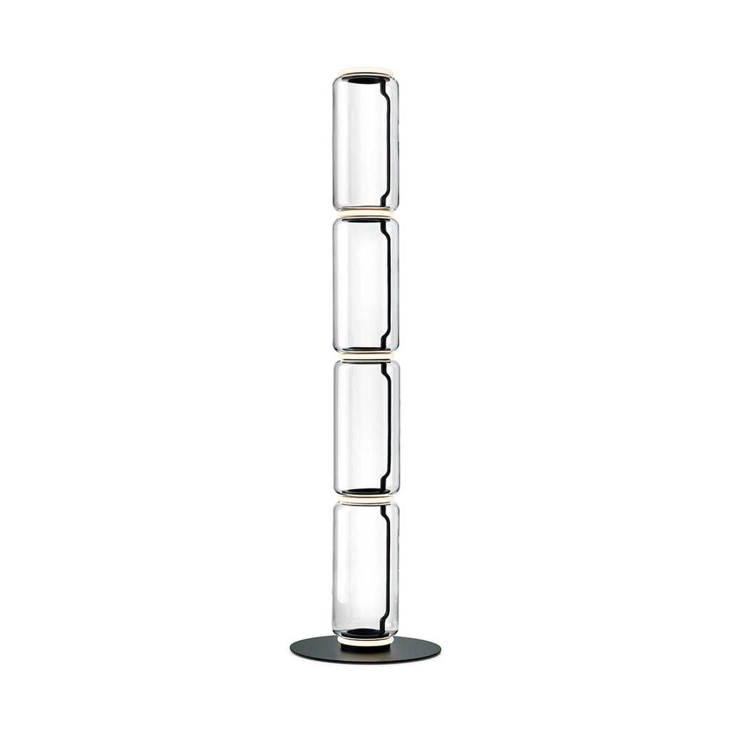 Tall Clérachic floor lamp on white, four stacked clear glass cylinders with light rings and a round black base.