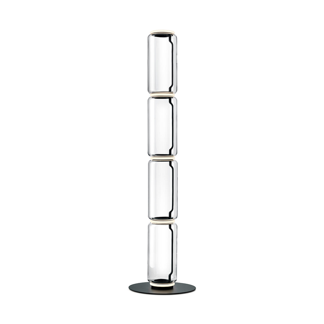 Tall Clérachic floor lamp on white, four stacked clear glass cylinders with light rings and a round black base.