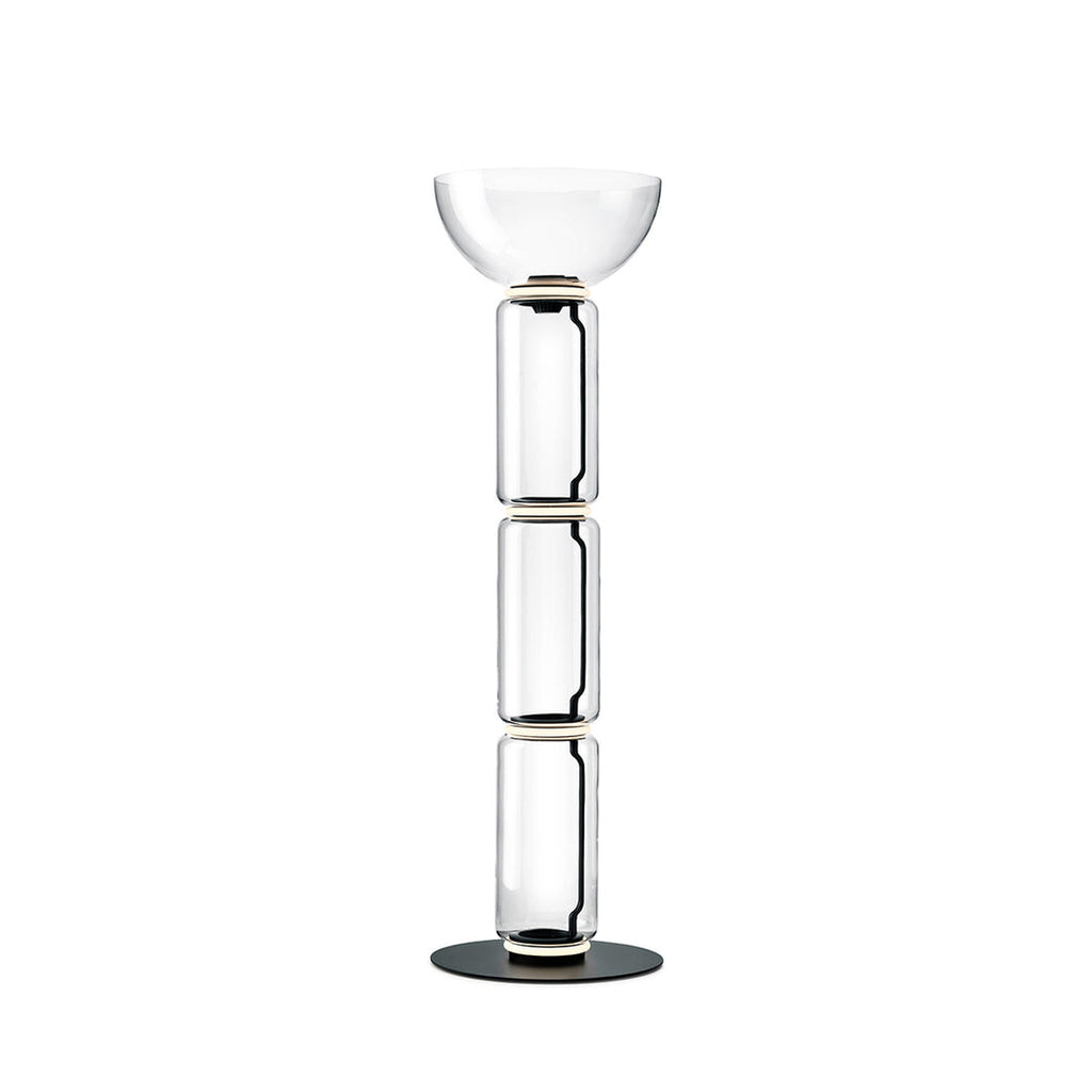 Clérachic floor lamp on white with a wide glass bowl on top of three stacked glass cylinders and a round black base.