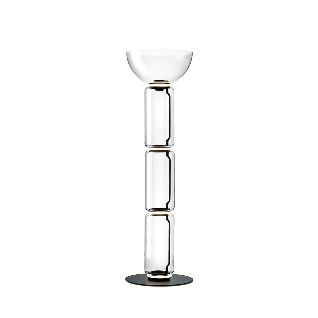 Clérachic floor lamp on white with a wide glass bowl on top of three stacked glass cylinders and a round black base.