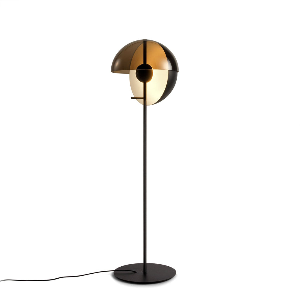 Three-quarter view of the black floor lamp on white, the smoked dome open over a frosted globe, with a cord trailing from the base; Clérachic.