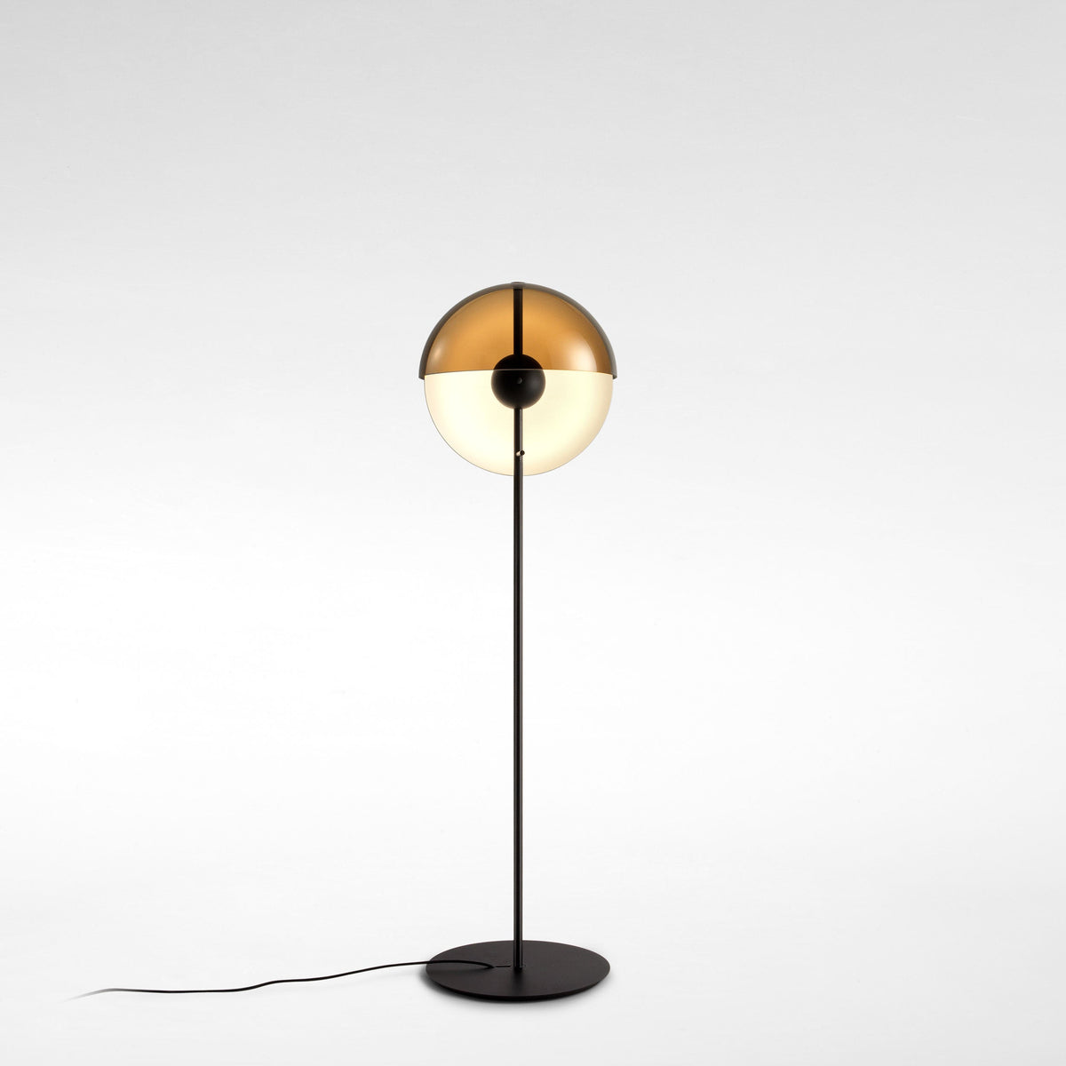 Floor lamp with the dome tilted up, showing a warm bronze inside and a pale globe below, on a pale studio backdrop; from Clérachic.