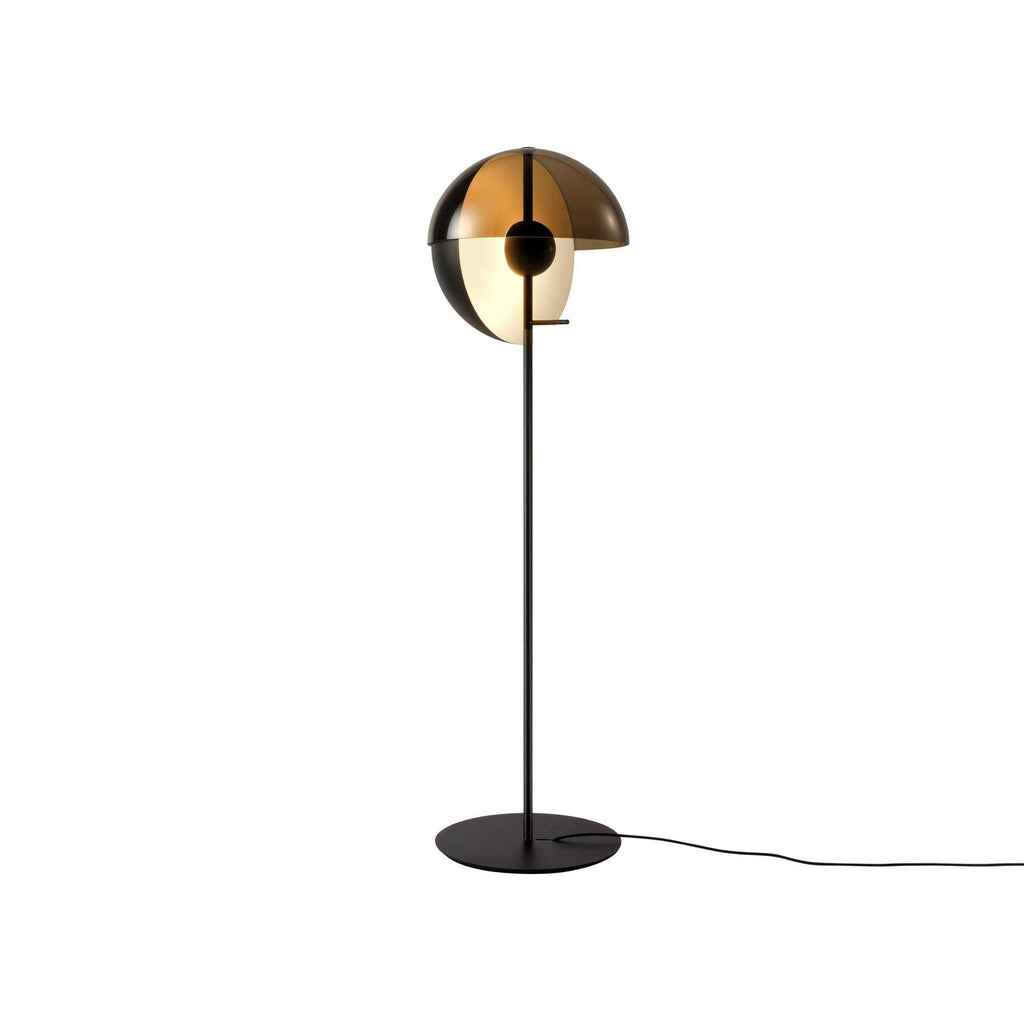 Black floor lamp with the dome open to the side, a frosted globe inside and a thin cord leaving the round base; from Clérachic.