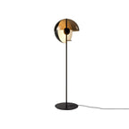 Black floor lamp with the dome open to the side, a frosted globe inside and a thin cord leaving the round base; from Clérachic.