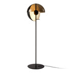 Close view of the black Clérachic floor lamp, showing the split bronze shade, the black ball joint and the round base.