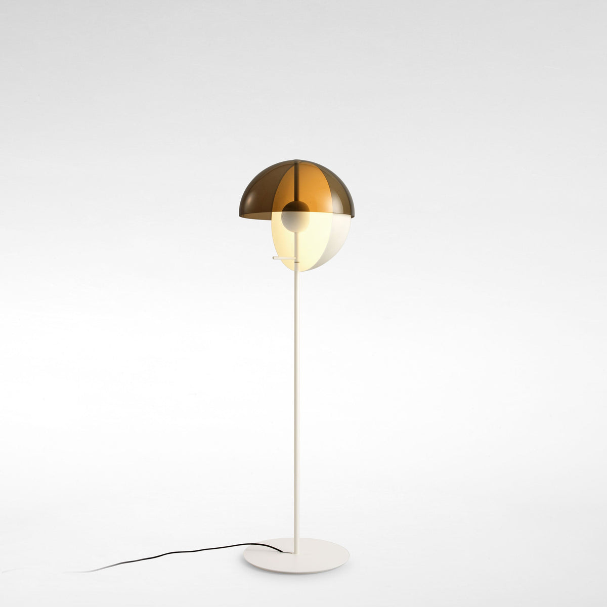 White version of this Clérachic floor lamp on a pale grey studio floor, its bronze dome open above a slim white stem.