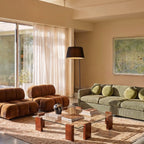 Clérachic black arc floor lamp with a fabric shade standing in a bright living room with a striped sofa.