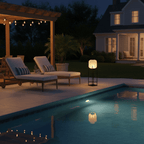Clérachic lantern with a warm glow on a poolside terrace at night, with sun loungers and a lit house across the water.