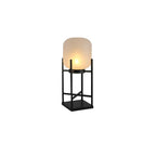 This Clérachic solar lantern on a white background, lit warm inside its frosted glass shade on a black square-based frame.