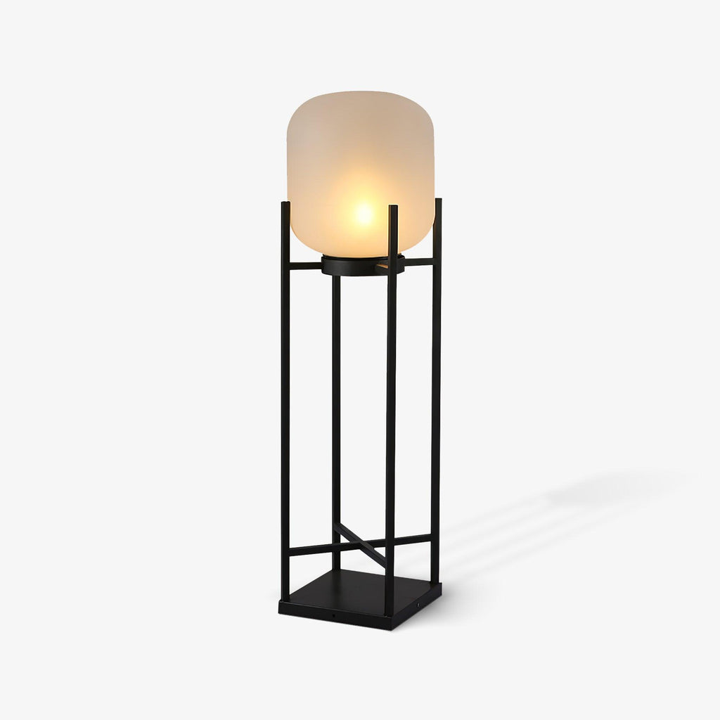 Angled view of this Clérachic lantern lit on a pale grey background, with its frosted shade and black cross-braced frame.