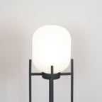 Close view of the rounded white glass shade of this Clérachic lantern, held in the top of its charcoal frame.