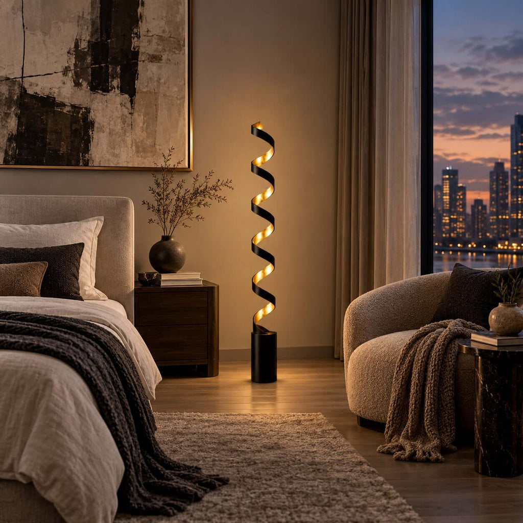 Evening view of a bedroom with this Clérachic spiral floor lamp lit beside a dark wooden nightstand and a window onto the city lights.