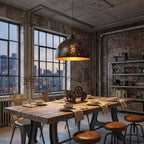 Single Clérachic dome pendant above a reclaimed-wood dining table in an industrial room, with city views through tall paned windows.