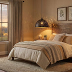 Clérachic dome pendant glowing over a bed with cream linen and a knitted throw, casting a speckled pattern on the warm wall.