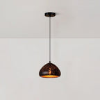 Low, wide Clérachic pendant with a rounded black shade dotted with small perforations, hanging from a ceiling plate on a white wall.