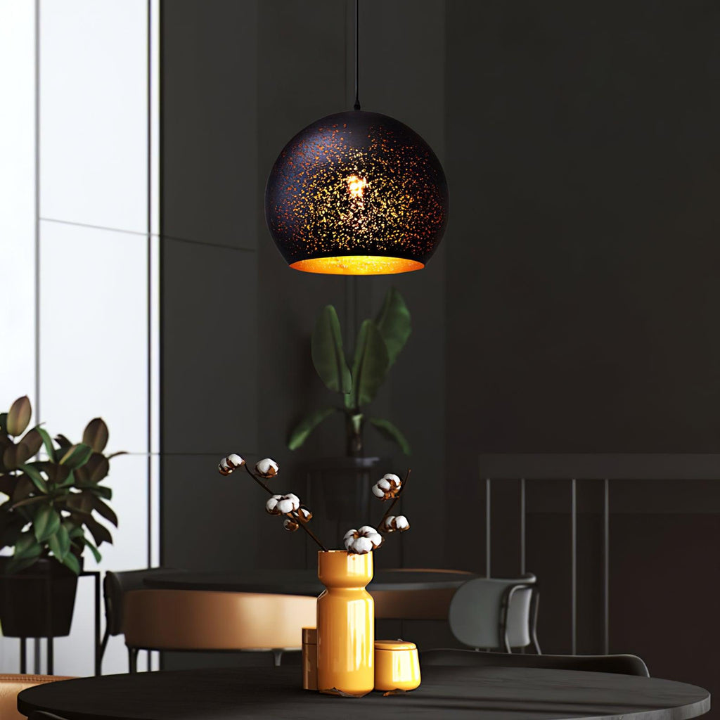 Round Clérachic pendant lit above a dark table with a yellow vase of cotton stems, in a charcoal-walled room with a window.