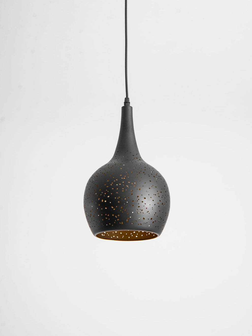 Teardrop Clérachic pendant tilted slightly toward the camera, showing the gold lining inside its perforated black shade.