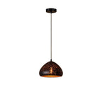 Low, wide Clérachic pendant with a rounded black shade and a gold lining, hanging from a ceiling plate on a white backdrop.