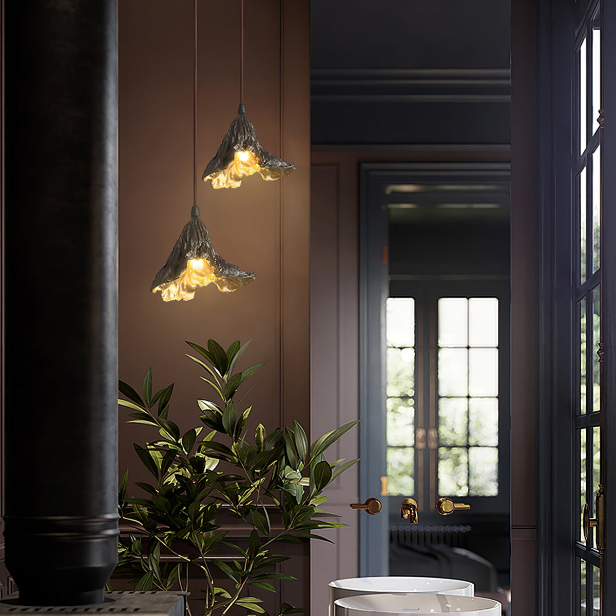 Two Clérachic pendants with leaf-shaped dark shades glow gold in a brown-walled hallway with a plant and a glazed door.