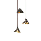 Three Clérachic pendants with gold-lit insides hang at three heights on a white backdrop, the shades crinkled like leaf edges.