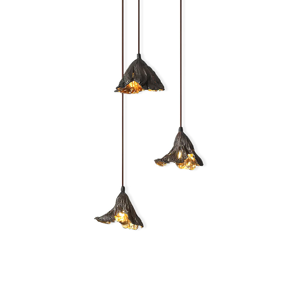 Three Clérachic pendants with gold-lit insides hang at three heights on a white backdrop, the shades crinkled like leaf edges.