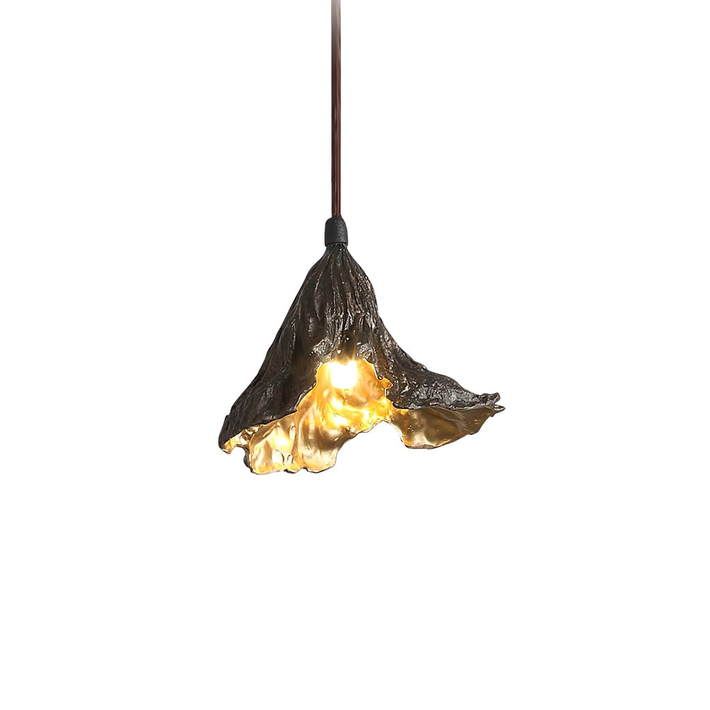 Close view of one Clérachic pendant on a white backdrop, its blackened ruffled shade glowing gold along the rim.