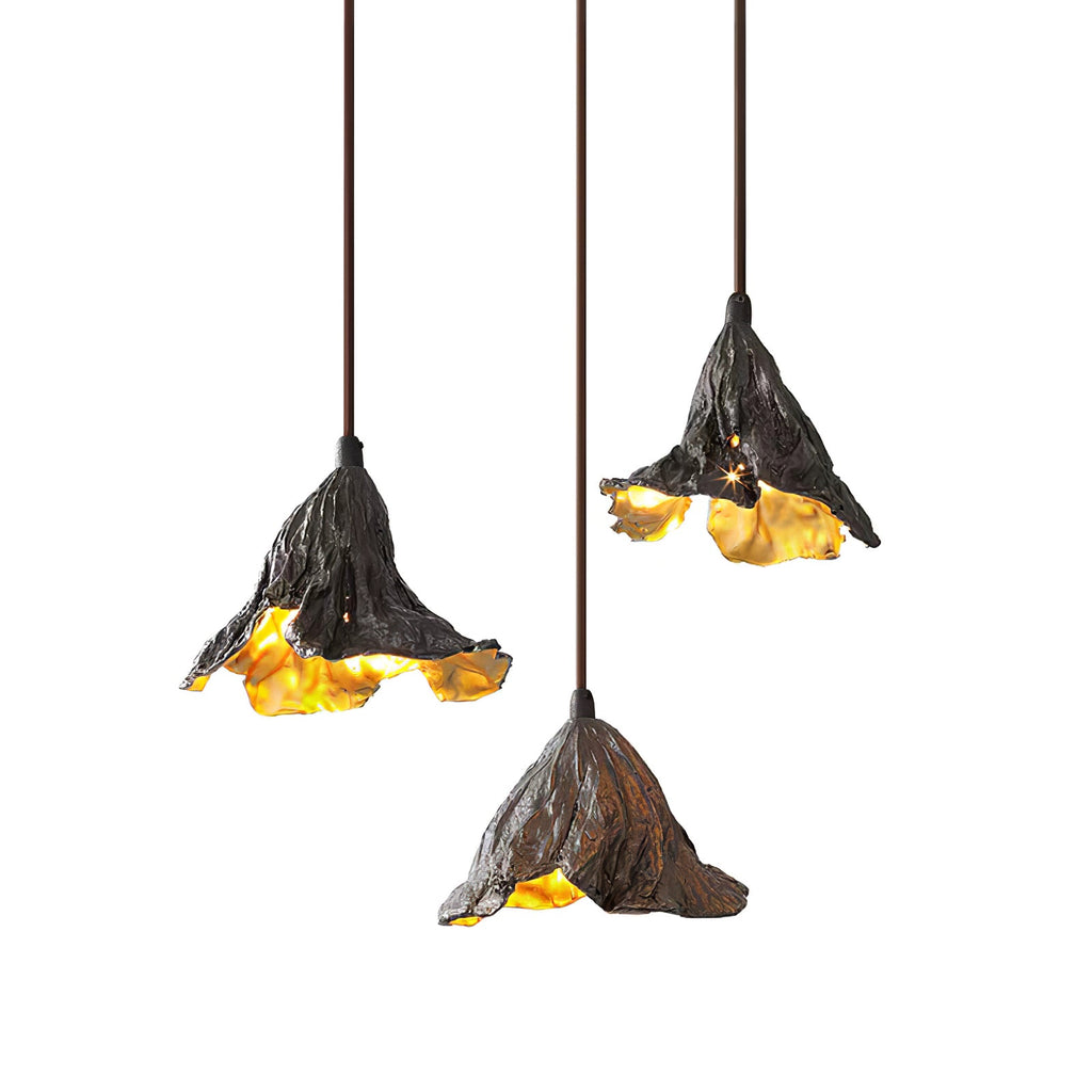 Three Clérachic pendants with ruffled dark shades hang at three heights, the gold interiors glowing against white.