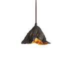 One Clérachic pendant with a rough dark shade and a gold underside hangs from a dark cord on a white backdrop.